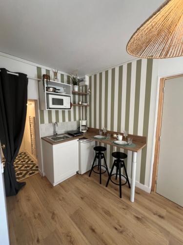 une petite cuisine avec un évier et une table dans l'établissement Petit nid en bord de mer, à Ouistreham