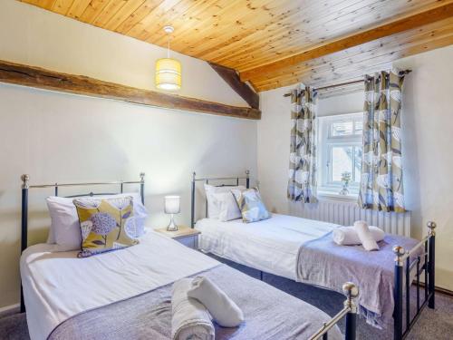 two beds in a room with wooden ceilings at 4 Bed in Keswick 86250 in Threlkeld