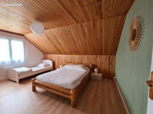 - une chambre avec un plafond en bois et un lit dans l'établissement Grand gîte avec jacuzzi à La Turballe, à La Turballe