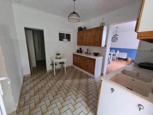 une cuisine avec un évier et une table à l'intérieur dans l'établissement Grand gîte avec jacuzzi à La Turballe, à La Turballe