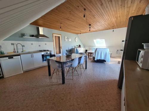 une cuisine avec une table et des chaises dans une pièce dans l'établissement Grand gîte avec jacuzzi à La Turballe, à La Turballe