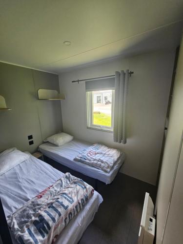 two beds in a small room with a window at loggia 29 in Biville-sur-Mer
