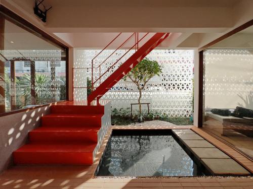 a house with a red staircase and a pond at Sense of Jedyod - near Maya Nimman in Chiang Mai