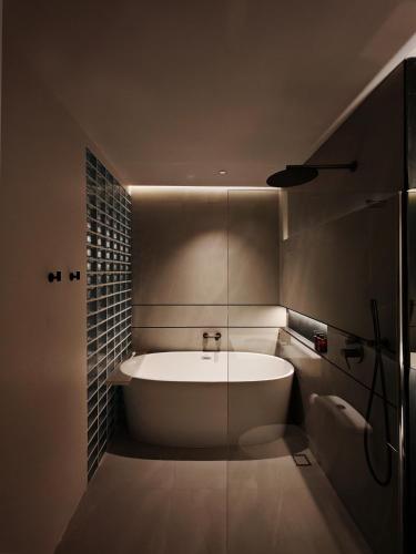 a bathroom with a bath tub and a sink at Sense of Jedyod - near Maya Nimman in Chiang Mai