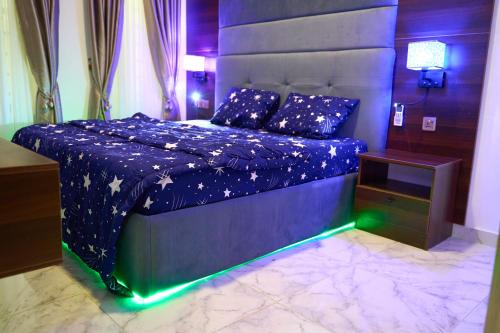 a bedroom with a blue bed with a blue comforter with lights at ABOT Luxury Homes in Lekki