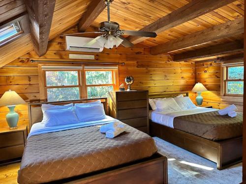 a bedroom with two beds in a log cabin at Forest Tree Log Cabin in Middletown