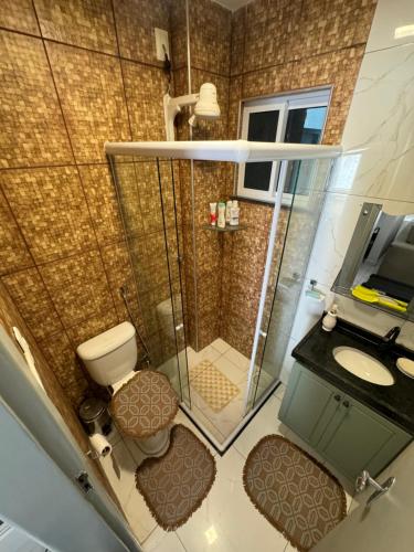 ein Badezimmer mit Dusche, Toilette und Waschbecken in der Unterkunft Duplex mobiliado no cumbuco in Caucaia