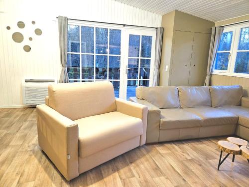 una sala de estar con un sofá y dos sillas en CHALET ARDENTARDENNE - Durbuy, en Durbuy