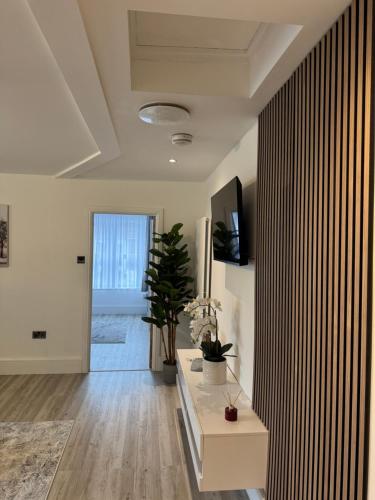 a living room with a table and a plant at 2 Bedroom luxury apartments in Bristol