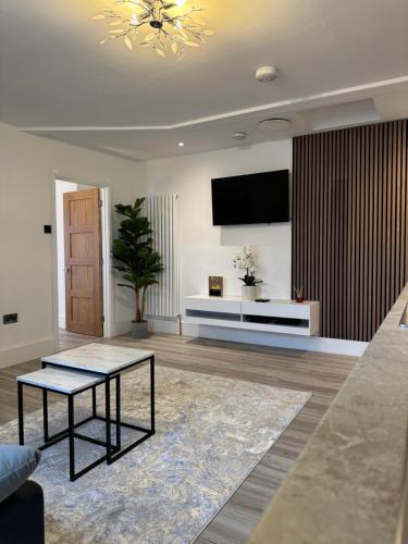 a living room with a tv and a table at 2 Bedroom luxury apartments in Bristol