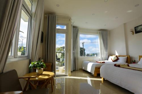 a hotel room with two beds and windows at KS Thanh Thùy in Xuan An