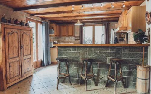 une cuisine avec deux tabourets de bar et un comptoir dans l'établissement Maison accueillante avec vue sur montagnes à Villarembert, à Villarembert