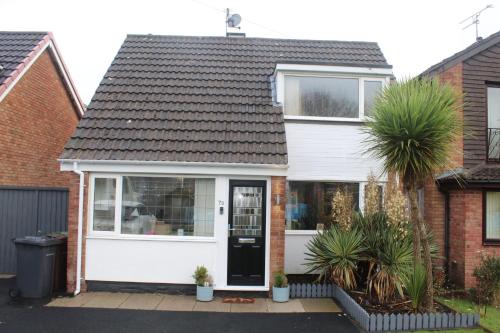 a white house with a black door at Beautiful home near beach in Formby