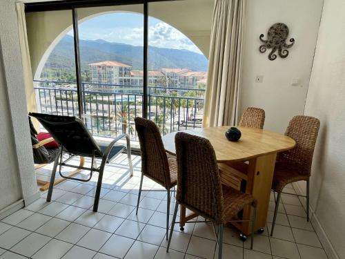 une salle à manger avec une table et des chaises et une grande fenêtre dans l'établissement Argelès sur mer- Appartement 4 pièces AR370-050, à Argelès-sur-Mer