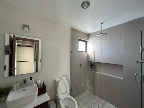 a bathroom with a toilet and a sink and a shower at Malecón Love in Mazatlán
