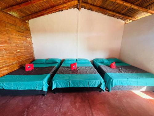 a room with two green beds in it at Estadero Los hoyos in Villavieja