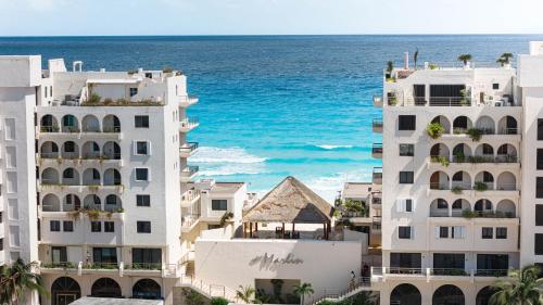 a view of the ocean from between two buildings at Marlin by Andiani Travel in Cancún