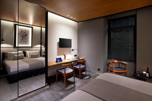 a hotel room with a bed and a desk and a bed at MET34 Athens in Athens