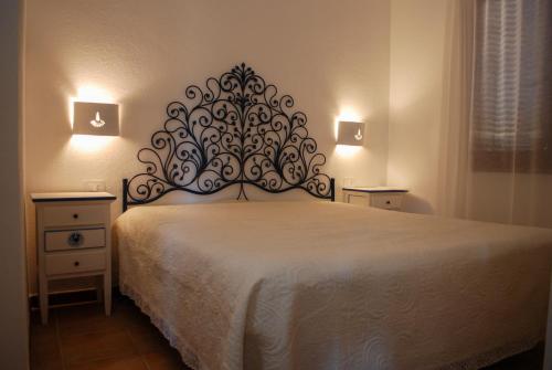 Bett in einem Zimmer mit zwei Nachttischen und einem Bett mit einem Kopf in der Unterkunft La Terrazza sul Mare in San Teodoro