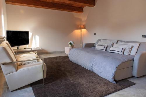 Un dormitorio con una cama grande y un sofá. en Frabosa White Week Elegant APT 4beds 10 min to Ski Station, en Frabosa Sottana