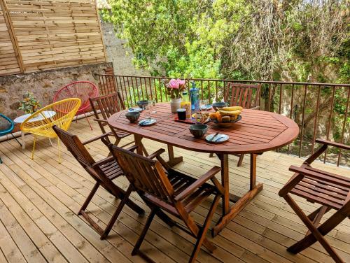 une table et des chaises en bois sur une terrasse en bois dans l'établissement Proche centre ville avec une belle terrasse, à Perpignan