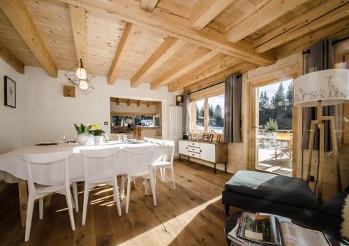 une salle à manger avec une table et des chaises blanches dans l'établissement Chalet en famille - nature, bain nordique, détente, à Crest-Voland
