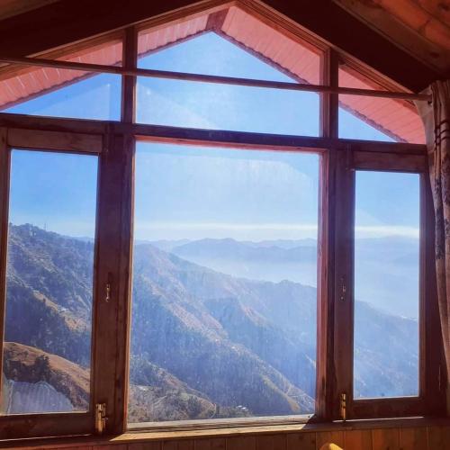 a window with a view of a mountain view at Ashirwad Homestay near Kufri in Theog