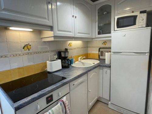 une cuisine avec un réfrigérateur blanc et un évier dans l'établissement Maison 2 pièces mezzanine 6 couchages AR510-048, à Argelès-sur-Mer