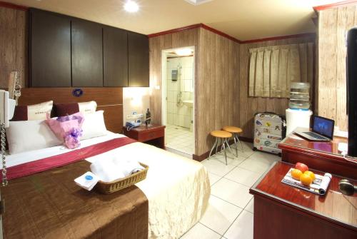 a hotel room with a bed and a bathroom at Golden Swallow Hotel in Hsinchu City