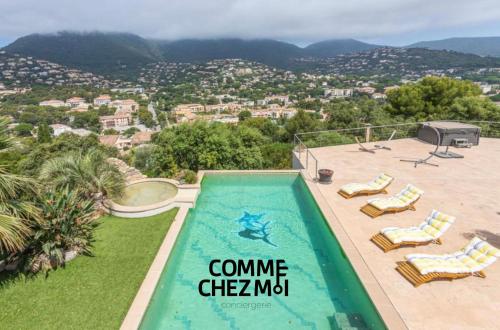 - une piscine avec des chaises et une vue sur la ville dans l'établissement Villa luxueuse pour 10 personnes à Cavalaire-sur-Mer avec piscine et jacuzzi à 30 minutes de St TROPEZ, à Cavalaire-sur-Mer