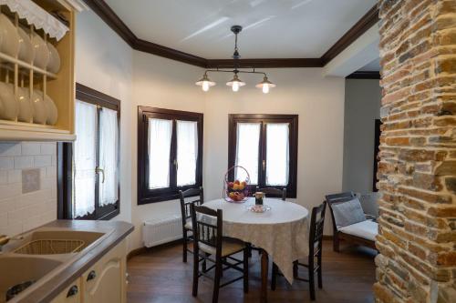 Una cocina y un comedor con mesa y sillas. en Alorama Luxury House in Pelion, en Drakeia