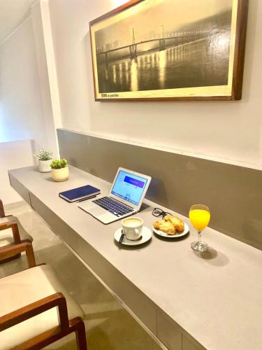 a desk with a laptop and a plate of food at ALWA Suites in Resistencia