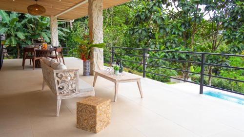a patio with a table and a chair on a balcony at House 15 Min From The Beach With River Access in Ojochal
