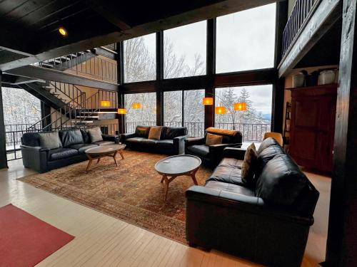 a living room with couches and tables and windows at RL Breathtaking views and grand unique style private mountain retreat 4WD recommended in Whitefield