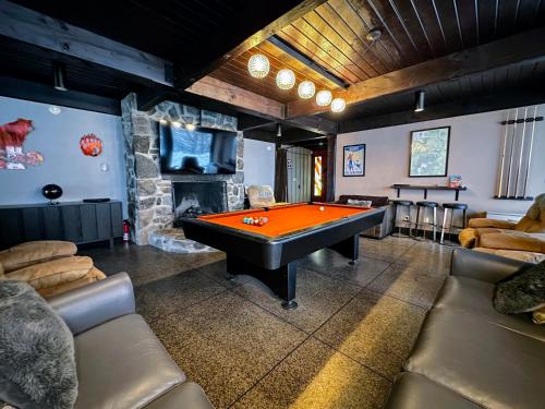 a room with a pool table and a stone fireplace at RL Breathtaking views and grand unique style private mountain retreat 4WD recommended in Whitefield