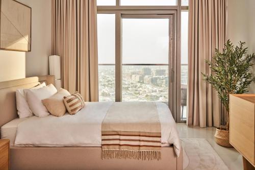 a bedroom with a large bed with a large window at Luxury Seaview 2BR - Paramount Midtown - 6 Guests - 64F Pool Access & Burj View in Dubai