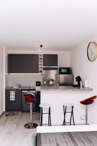 une cuisine avec un comptoir et des tabourets dans une pièce dans l'établissement Appartement , Strasbourg France, à Strasbourg
