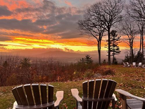 two chairs sitting on top of a hill with a sunset at RL Breathtaking views and grand unique style private mountain retreat 4WD recommended in Whitefield