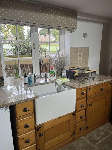 a kitchen with a sink and a large window at Corner Cottage in Knaresborough