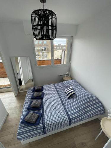 un grand lit dans une chambre avec une fenêtre dans l'établissement AZUR Bel appartement côté mer !, à Villers-sur-Mer