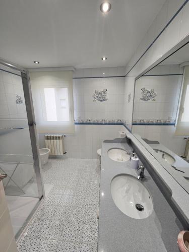 a bathroom with two sinks and a mirror at Exclusivo apartamento en la mejor zona de Tarragona in Tarragona