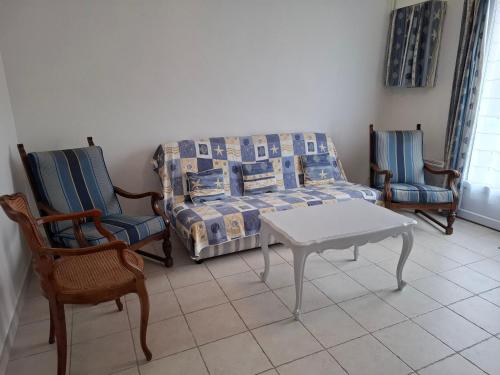 un salon avec un canapé et deux chaises dans l'établissement Les MOUSSES, à Varaville