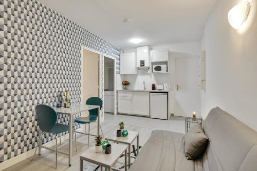 un salon avec un canapé, une table et des chaises dans l'établissement Bluestay 137 - Charming apartment, à Bagnolet