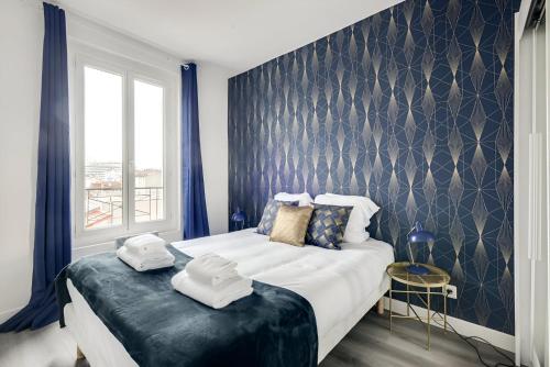 une chambre avec un grand lit avec des serviettes dessus dans l'établissement Bluestay 137 - Charming apartment, à Bagnolet