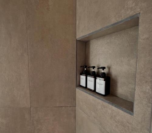 a bathroom with three bottles of wine on a shelf at The Mermaid and The Pearl Boutique Hotel in Isla Mujeres