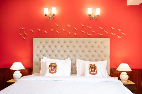 a bedroom with a white bed with red walls at Wizards Den-Harry Potter inspired 3BHK in Mashobra in Mashobra