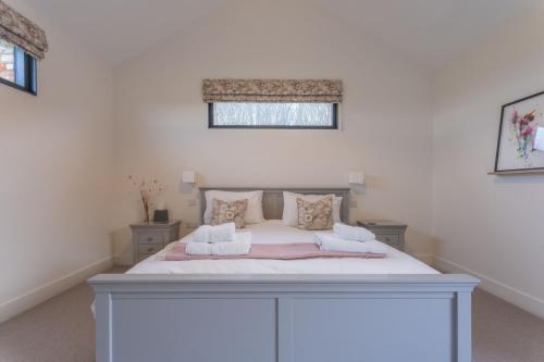 Un dormitorio con una gran cama blanca en una habitación. en Gallops, en East Ilsley