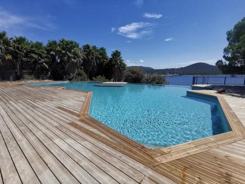 - une piscine avec une terrasse en bois et de l'eau dans l'établissement Résidence de charme T3 avec piscine et accès plage, à Viagenti