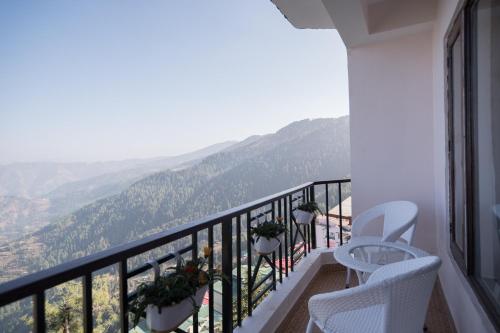 a balcony with two chairs and a view of the mountains at Wizards Den-Harry Potter inspired 3BHK in Mashobra in Mashobra