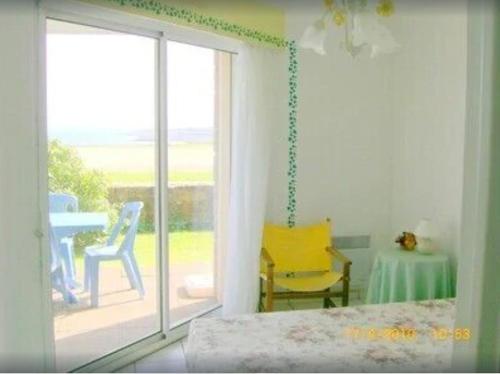 a room with a sliding glass door with a table and chairs at Appartement T2, RDJ, 2 étoiles, Vue mer panoramique, Côte de Granit Rose in Perros-Guirec